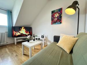 a living room with a couch and a tv at M Lorry Pop Art 3 chambres avec balcons proche Metz in Metz