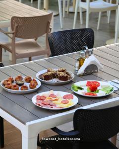 a table with three plates of food on it at Low Cost Hotel Kosova in Shëngjin