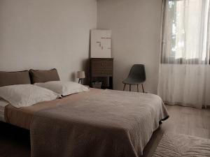 a bedroom with a bed and a dresser and a window at Le Tranquil in Annecy