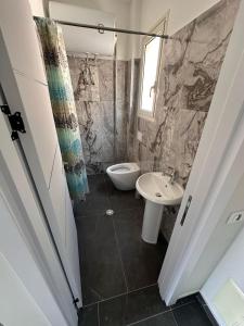 a bathroom with a toilet and a sink at TRIUMPH rooms and apartment in Vlorë