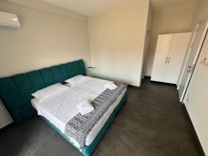 a bedroom with a green bed with white sheets at TRIUMPH rooms and apartment in Vlorë