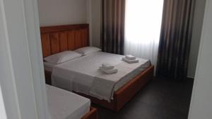 a bedroom with a bed with two towels on it at TRIUMPH rooms and apartment in Vlorë +5 photos