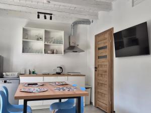 a kitchen with a wooden table and blue chairs at 9azaliowa - Domy całoroczne w Dębinie in Debina