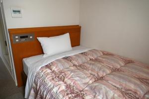 Un dormitorio con una cama con una almohada encima. en アイリスイン知立, en Chiryu 6 fotos más