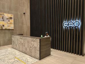 a man sitting at a reception desk in a building at Wonderful Geo Bukit Rimau Condominium in Shah Alam