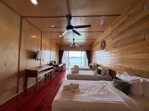 a hotel room with two beds and a ceiling fan at Nusakuya Resort in Semporna