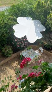 Una estatua de oso blanco en un jardín con flores. en CASA INDIPENDENTE con giardino-min 3 notti, en Castiglione del Lago