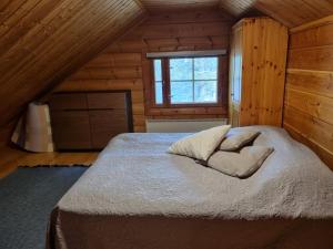 a bedroom with a bed in a wooden cabin at 90m2 vacation home in Ruka in Kuusamo