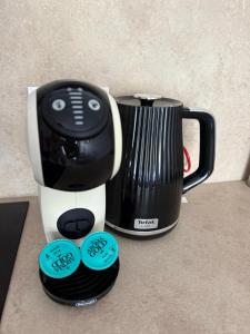 a black and white blender sitting next to a cup at Apartamentai-studija Palangos kopos in Palanga