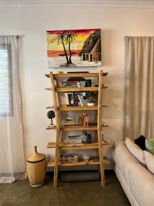 a book shelf in a living room with a couch at Mambo & Jambo Homestay in Mwanza