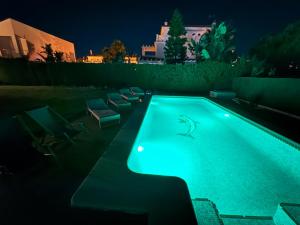 a swimming pool lit up at night at Holiday house with private pool, Costa de la Luz in El Portil