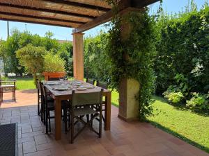 a dining table under a pergola in a garden at Forte Classic Stylish Villa in Forte dei Marmi