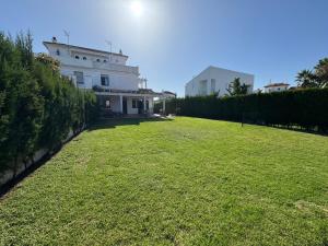 a large lawn in front of a white building at Holiday house with private pool, Costa de la Luz in El Portil +65 photos
