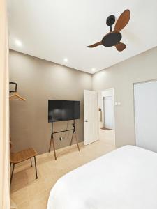 a bedroom with a bed and a flat screen tv at The Palm House in Dauis +32 photos