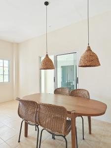 a dining room with a wooden table and chairs at The Palm House in Dauis +27 photos