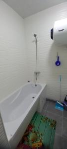 a white bathroom with a tub and a shower at 1 кімнатні апартаменти в гостьовому будинку in Mukacheve