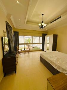 une chambre avec un lit, une table et des chaises dans l'établissement Albarsha Villa Fully Furnished Luxury Private Master Room Ensuite Huge Space Deluxe, à Sabkhah