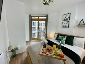 a bedroom with a bed and a tray of food on a table at Marshall Street Retreat in Birmingham