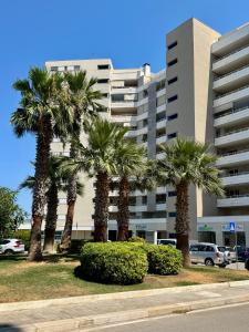 a group of palm trees in front of a building at Best Stay-Airport Bari Palese in Macchie +18 photos