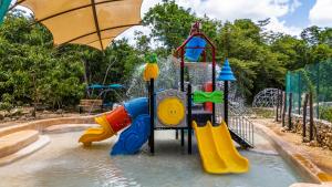 a water park with a playground with a slide at Spazi Ha Glamping & Cenote in Yalcobá