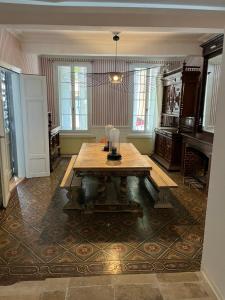 une salle à manger avec une table et une cheminée dans l'établissement Maison de maître de 700 m2 en plein cœur de Castelnaudary, à La Celle-sous-Gouzon