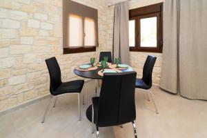 a dining room with a table and black chairs at Villa Mykeli in Kriopigi +36 photos