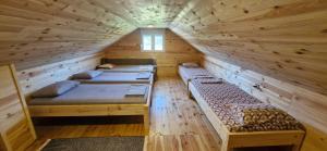 a room with four beds in a log cabin at Village House in Veruša