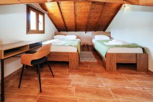 a room with two beds and a desk and a chair at Villa Mykeli in Kriopigi