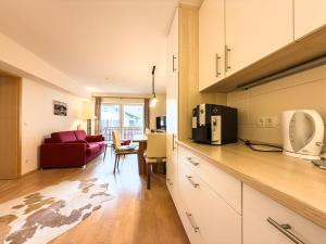 a kitchen and living room with a red couch at Alm Loge in Oberstaufen