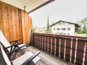 a balcony with two chairs and a wooden fence at Alm Loge in Oberstaufen