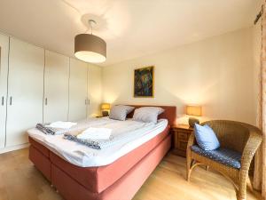a bedroom with a bed and a chair at Alm Loge in Oberstaufen