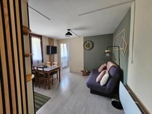 a living room with a couch and a table at Appartement 1-4 personnes, Résidence "Le Belouga" in Le Mont-Dore +12 photos
