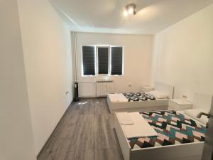 a white room with two beds and a window at NDK NEST 2BR Apartment in the Heart of Sofia in Sofia