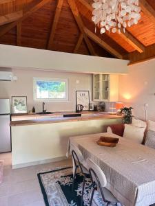 a kitchen and living room with a table and a counter at Oaza Vrbas - Riverside Bungalow in Jajce