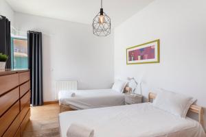 a white room with two beds and a dresser at Marina Pool & Sea in Páteo