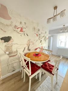 a dining room with a table and chairs and a mural at Ania's Apartment in Horezu +28 photos