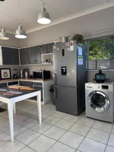 a kitchen with a refrigerator and a washing machine at House Fynbos, 4 Bedroom house in Bloemfontein