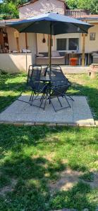 a table and two chairs under an umbrella at Györgyök Háza in Eger