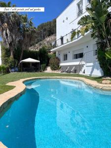 ein großer blauer Swimmingpool vor einem Gebäude in der Unterkunft Villa Oasis Costa Brava in Lloret de Mar
