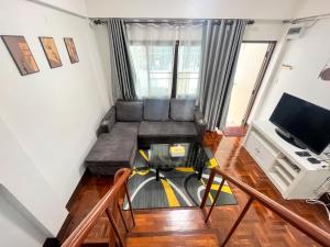 a living room with a couch and a tv at Warm House CNX ใกล้นิมมาน เมญ่า สันติธรรม in Chiang Mai
