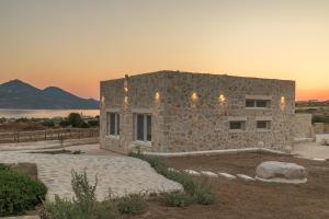 a stone house with a sunset in the background at Milo Stone Villas in Zefiría