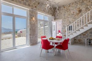 a dining room with a table and red chairs at Milo Stone Villas in Zefiría