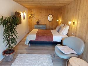a bedroom with a bed and a potted plant at Au Mont Chablis in Champagnole