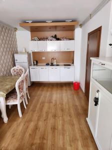 cocina con armarios blancos y suelo de madera en Sweet Homes, en Sunny Beach