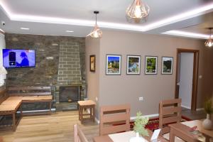 a living room with a fireplace and a tv on the wall at Vila Culli in Përmet