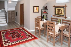 ein Esszimmer mit Tisch, Stühlen und einem Teppich in der Unterkunft Vila Culli in Përmet