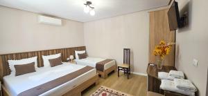 a hotel room with two beds and a television at Vila Culli in Përmet