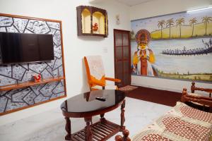a living room with a chair and a flat screen tv at Alleppey Haven 6BR Whole House by Backwater in Alleppey