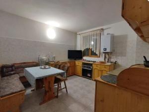 Una sala de estar con una mesa y una cocina. en Casa Iancu, en Râșnov