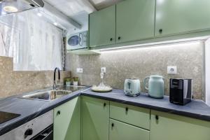 a kitchen with green cabinets and a sink at Maritina Skopelos Maisonette in Skopelos Town